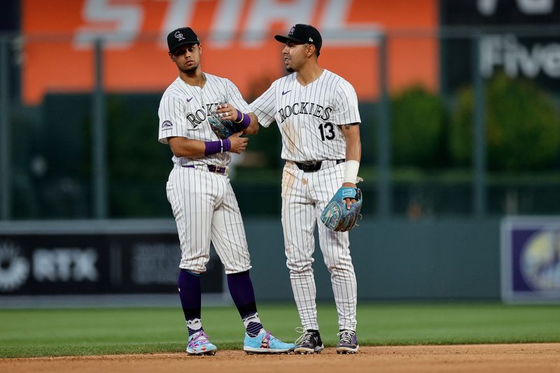 Jun 18, 2024; Denver, Colorado, USA; Colorado Rockies shortstop Ezequiel Tovar (14) and second baseman Alan Trejo (13) in the seventh inning against the Los Angeles Dodgers at Coors Field. Mandatory Credit: Isaiah J. Downing-USA TODAY Sports