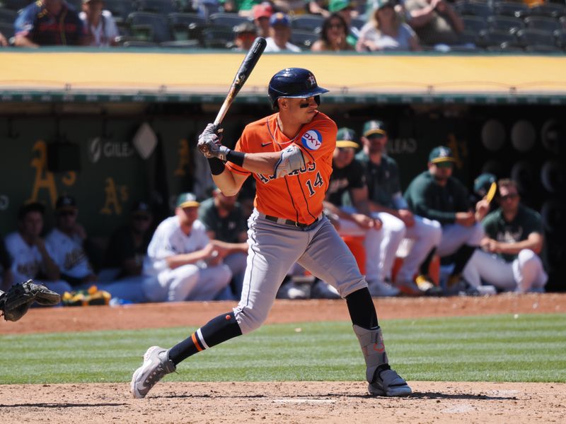 Jul 23, 2023; Oakland, California, USA; Houston Astros second baseman Mauricio Dubon (14) winds up before hitting a solo home run against the Oakland Athletics during the ninth inning at Oakland-Alameda County Coliseum. Mandatory Credit: Kelley L Cox-USA TODAY Sports