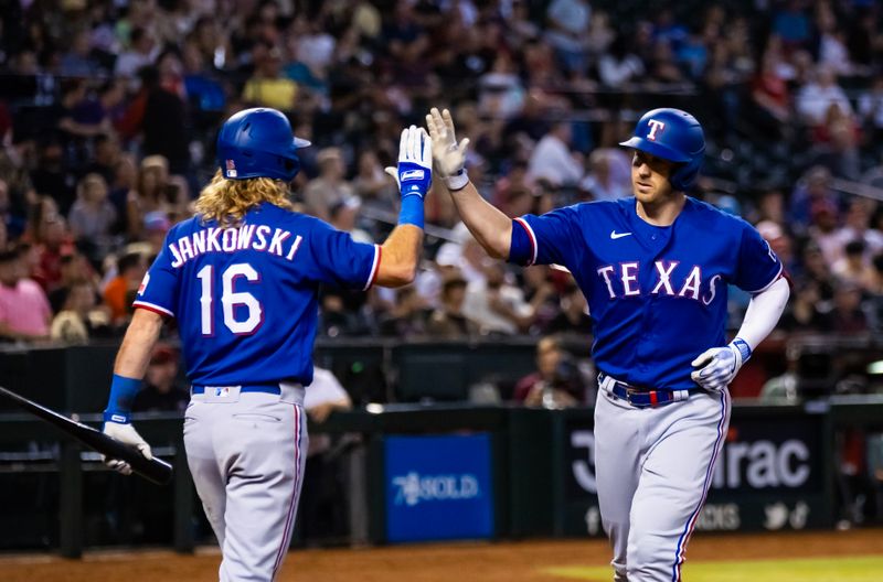 Aug 22, 2023; Phoenix, Arizona, USA; Texas Rangers catcher Mitch Garver (right) celebrates with teammate Travis Jankowski after hitting a solo home run in the sixth inning against the Arizona Diamondbacks at Chase Field. Mandatory Credit: Mark J. Rebilas-USA TODAY Sports