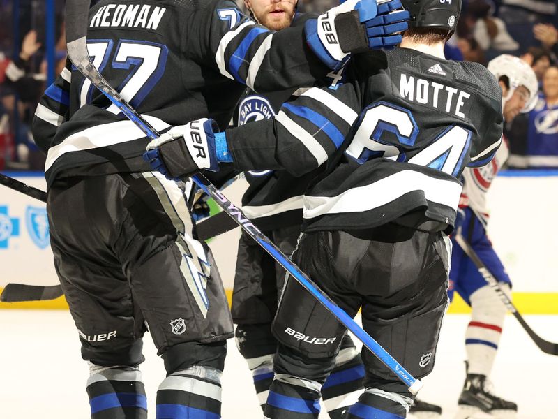 Mar 2, 2024; Tampa, Florida, USA;  Tampa Bay Lightning center Tyler Motte (64) celebrates with Tampa Bay Lightning defenseman Victor Hedman (77) and teammates after scoring a goal against the Montreal Canadiens during the third period at Amalie Arena. Mandatory Credit: Kim Klement Neitzel-USA TODAY Sports