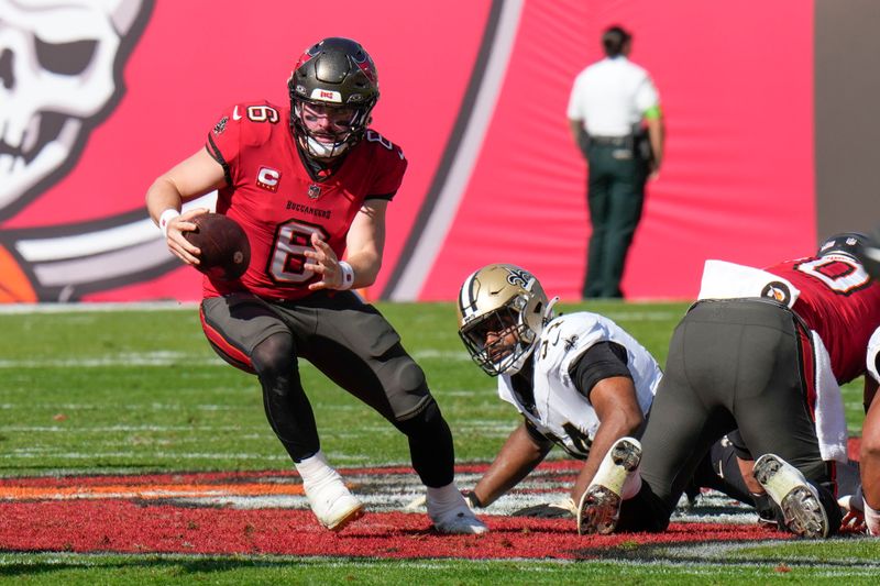 Tampa Bay Buccaneers quarterback Baker Mayfield (6) scrambles from New Orleans Saints defensive end Cameron Jordan (94) in the first half of an NFL football game in Tampa, Fla., Sunday, Dec. 31, 2023. (AP Photo/Chris O'Meara)