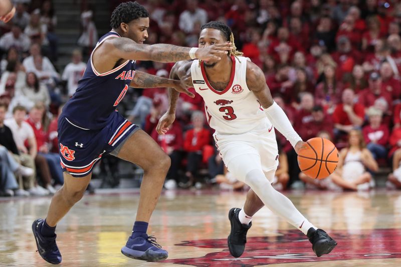 Jan 6, 2024; Fayetteville, Arkansas, USA; Arkansas Razorbacks guard El Ellis (3) drives against Auburn Tigers guard K.D. Johnson (0) during the second half at Bud Walton Arena. Auburn won 83-51. Mandatory Credit: Nelson Chenault-USA TODAY Sports