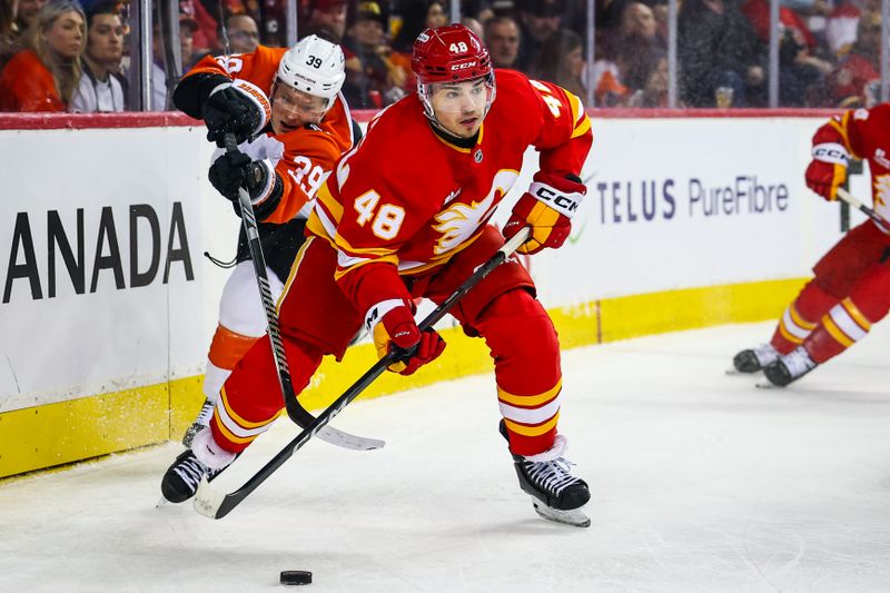 Dec 31, 2025; Calgary, Alberta, CAN; Calgary Flames defenseman Hunter Brzustewicz (48) controls the puck against Philadelphia Flyers right wing Matvei Michkov (39) during the first period at Scotiabank Saddledome. Mandatory Credit: Sergei Belski-Imagn Images