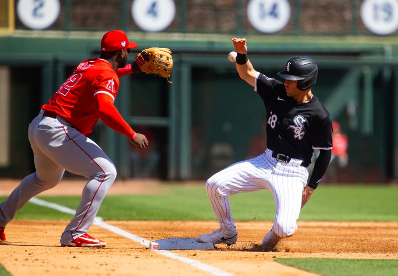 Mar 14, 2024; Phoenix, Arizona, USA; Chicago White Sox base runner Zach Remillard (right) slides safely into third base against Los Angeles Angels third baseman Miguel Sano during a spring training baseball game at Camelback Ranch-Glendale. Mandatory Credit: Mark J. Rebilas-USA TODAY Sports