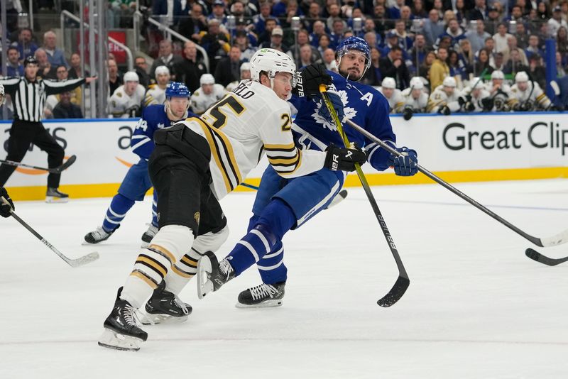 Apr 24, 2024; Toronto, Ontario, CAN; Boston Bruins defenseman Brandon Carlo (25) checks Toronto Maple Leafs forward Auston Matthews (34) during the first period of game three of the first round of the 2024 Stanley Cup Playoffs at Scotiabank Arena. Mandatory Credit: John E. Sokolowski-USA TODAY Sports