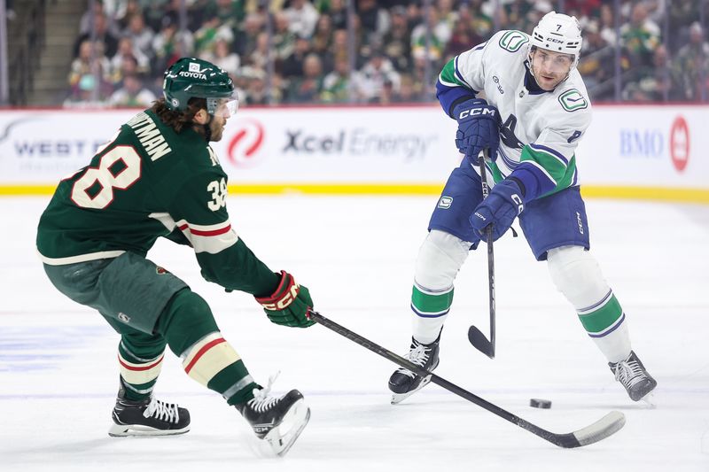 Dec 3, 2024; Saint Paul, Minnesota, USA; Vancouver Canucks defenseman Carson Soucy (7) passes as Minnesota Wild right wing Ryan Hartman (38) defends during the first period at Xcel Energy Center. Mandatory Credit: Matt Krohn-Imagn Images