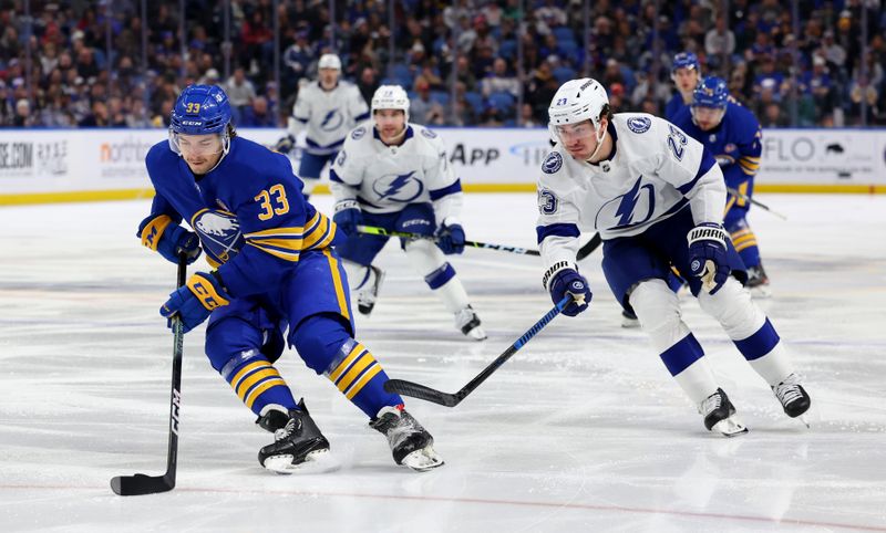 Jan 20, 2024; Buffalo, New York, USA;  Buffalo Sabres defenseman Ryan Johnson (33) skates with the puck as Tampa Bay Lightning center Michael Eyssimont (23) defends during the third period at KeyBank Center. Mandatory Credit: Timothy T. Ludwig-USA TODAY Sports