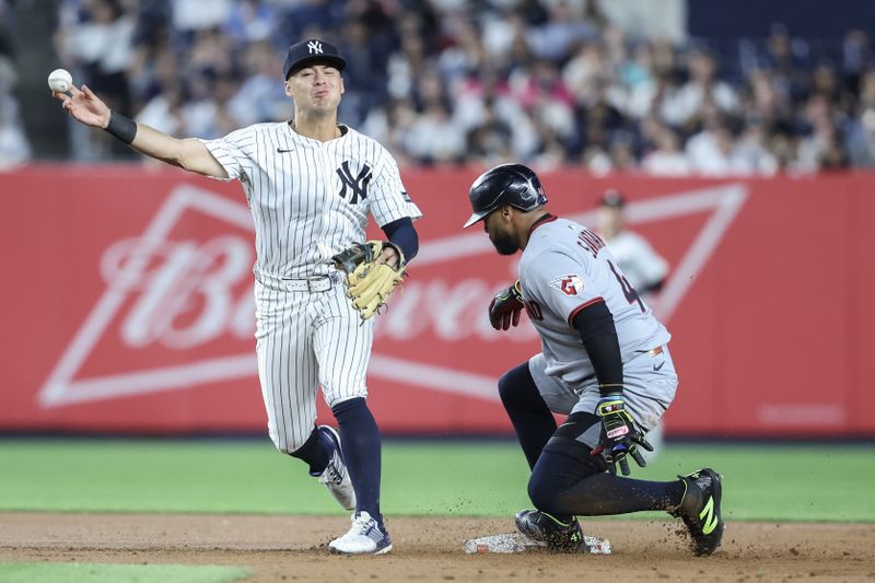 Jun 4, 2025; Bronx, New York, USA;  Cleveland Guardians designated hitter Carlos Santana (41) is forced out at second base as New York Yankees shortstop Anthony Volpe (11) attempts to turn a double play in the sixth inning at Yankee Stadium. Mandatory Credit: Wendell Cruz-Imagn Images