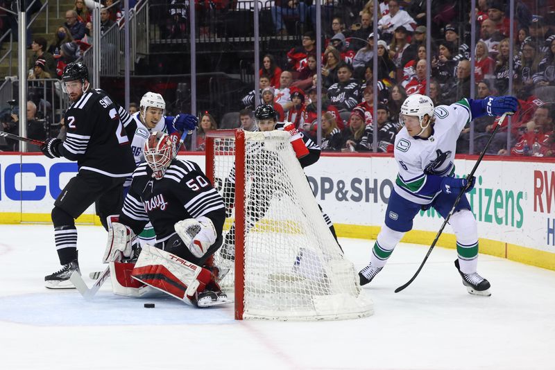 Jan 6, 2024; Newark, New Jersey, USA; New Jersey Devils goaltender Nico Daws (50) makes a save against the Vancouver Canucks during the first period at Prudential Center. Mandatory Credit: Ed Mulholland-USA TODAY Sports