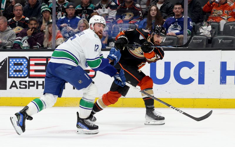 Mar 3, 2024; Anaheim, California, USA; Anaheim Ducks center Bo Groulx (24) shoots against Vancouver Canucks defenseman Filip Hronek (17) during the second period at Honda Center. Mandatory Credit: Jason Parkhurst-USA TODAY Sports