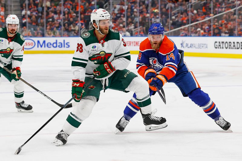 Feb 23, 2024; Edmonton, Alberta, CAN; Minnesota Wild forward Ryan Hartman (38) protects the puck from Edmonton Oilers defensemen Mattias Ekholm (14) during the second period at Rogers Place. Mandatory Credit: Perry Nelson-USA TODAY Sports