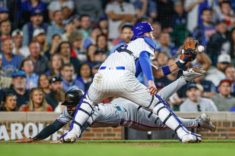 May 13, 2025; Chicago, Illinois, USA; Miami Marlins center fielder Derek Hill (3) scores against Chicago Cubs catcher Carson Kelly (15) during the seventh inning at Wrigley Field. Mandatory Credit: Kamil Krzaczynski-Imagn Images