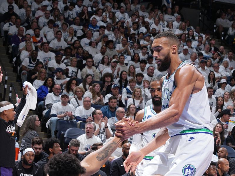 MINNEAPOLIS, MN -  APRIL 23: Karl-Anthony Towns #32 of the Minnesota Timberwolves is helped up by Rudy Gobert #27 and Mike Conley #10 during the game against the Phoenix Suns during Round One Game Two of the 2024 NBA Playoffs on April 23, 2024 at Target Center in Minneapolis, Minnesota. NOTE TO USER: User expressly acknowledges and agrees that, by downloading and or using this Photograph, user is consenting to the terms and conditions of the Getty Images License Agreement. Mandatory Copyright Notice: Copyright 2024 NBAE (Photo by Jordan Johnson/NBAE via Getty Images)