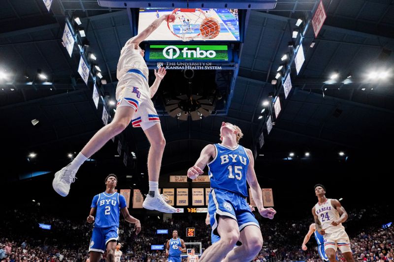 Feb 27, 2024; Lawrence, Kansas, USA; Kansas Jayhawks guard Johnny Furphy (10) dunks the ball as Brigham Young Cougars guard Richie Saunders (15) looks on during the first half at Allen Fieldhouse. Mandatory Credit: Denny Medley-USA TODAY Sports