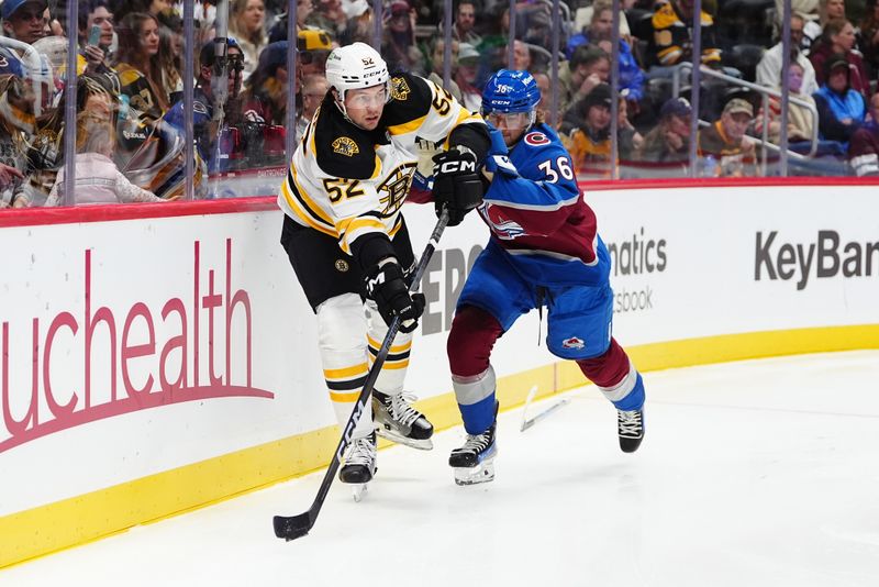 Oct 16, 2024; Denver, Colorado, USA; Colorado Avalanche center Matt Stienburg (36) and Boston Bruins defenseman Andrew Peeke (52) battle for the puck in the second period at Ball Arena. Mandatory Credit: Ron Chenoy-Imagn Images