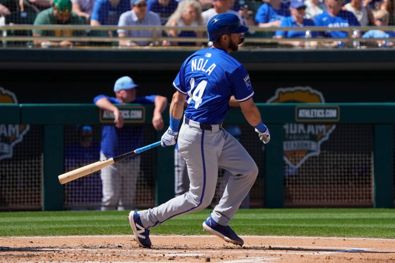 Mar 10, 2024; Mesa, Arizona, USA; Kansas City Royals catcher Austin Nola (14) hits a single against the Oakland Athletics in the second inning at Hohokam Stadium. Mandatory Credit: Rick Scuteri-USA TODAY Sports