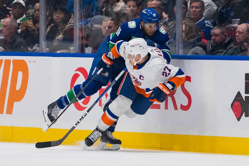 Nov 15, 2023; Vancouver, British Columbia, CAN; Vancouver Canucks forward Dakota Joshua (81) checks New York Islanders forward Anders Lee (27) in the first period at Rogers Arena. Mandatory Credit: Bob Frid-USA TODAY Sports