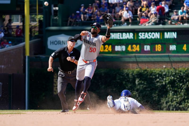 Aug 7, 2024; Chicago, Illinois, USA; Chicago Cubs shortstop Dansby Swanson (7) steals second base against Minnesota Twins shortstop Willi Castro (50) during the eighth inning at Wrigley Field. Mandatory Credit: David Banks-USA TODAY Sports