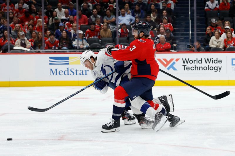 Oct 14, 2025; Washington, District of Columbia, USA; Tampa Bay Lightning center Brayden Point (21) battles for the puck with Washington Capitals defenseman Martin Fehérváry (42) and Capitals defenseman Matt Roy (3) in the second period at Capital One Arena. Mandatory Credit: Geoff Burke-Imagn Images