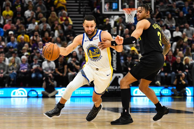 SALT LAKE CITY, UTAH - FEBRUARY 12: Stephen Curry #30 of the Golden State Warriors drives against Keyonte George #3 of the Utah Jazz during the first half at Delta Center on February 12, 2024 in Salt Lake City, Utah. NOTE TO USER: User expressly acknowledges and agrees that, by downloading and or using this photograph, User is consenting to the terms and conditions of the Getty Images License Agreement.  (Photo by Alex Goodlett/Getty Images)