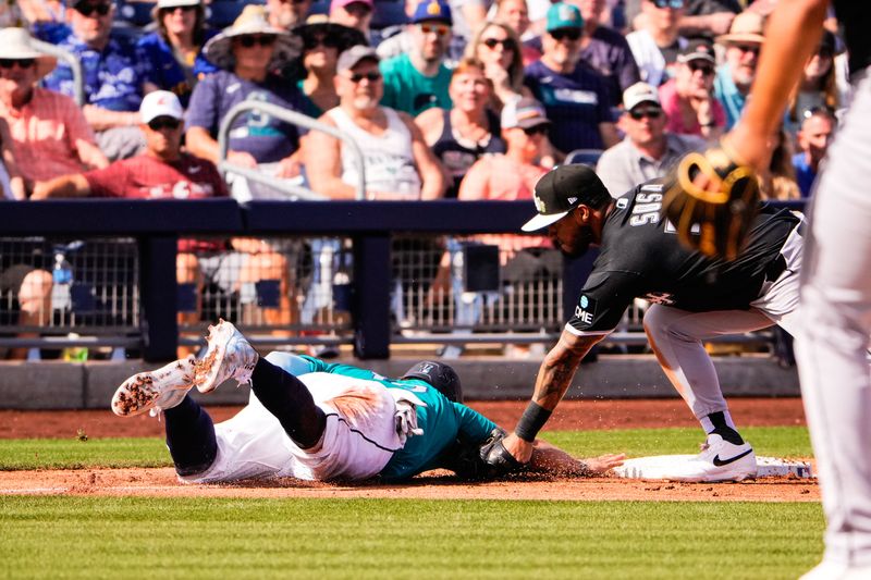 Feb 24, 2026; Peoria, Arizona, USA;  Chicago White Sox second baseman Lenyn Sosa (50) attempts to tag out Seattle Mariners first baseman Josh Naylor (12) during the third inning in Peoria, Arizona. Mandatory Credit: Arianna Grainey-Imagn Images