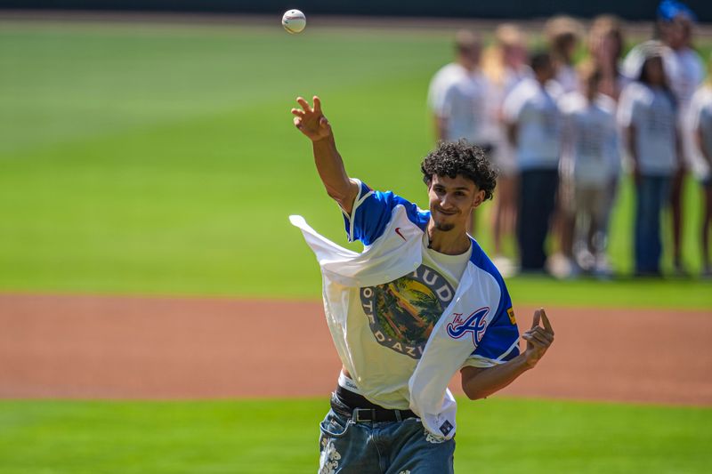 Jun 30, 2024; Cumberland, Georgia, USA; First draft pick in the NBA draft Atlanta Hawks Zaccharie Risacher throws out the first pitch before the game between the Pittsburgh Pirates and the Atlanta Braves at Truist Park. Mandatory Credit: Dale Zanine-USA TODAY Sports