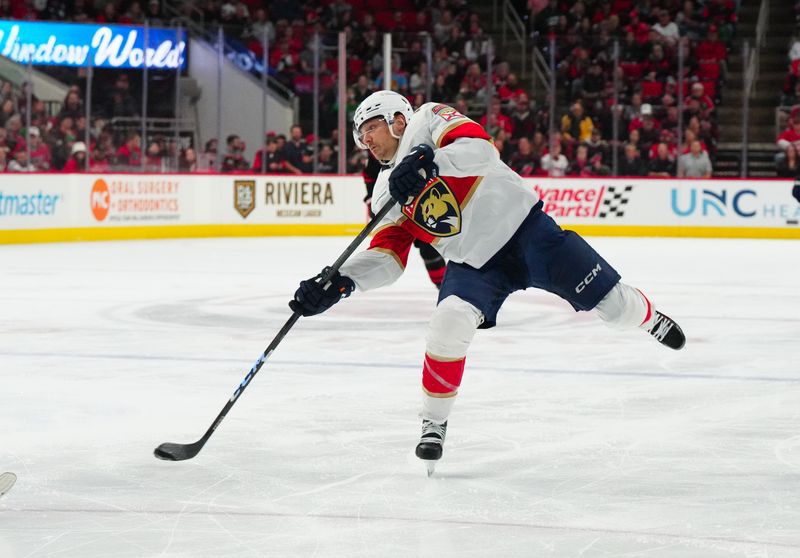 Mar 14, 2024; Raleigh, North Carolina, USA; Florida Panthers center Sam Reinhart (13) takes shot against the Carolina Hurricanes during the second period at PNC Arena. Mandatory Credit: James Guillory-USA TODAY Sports