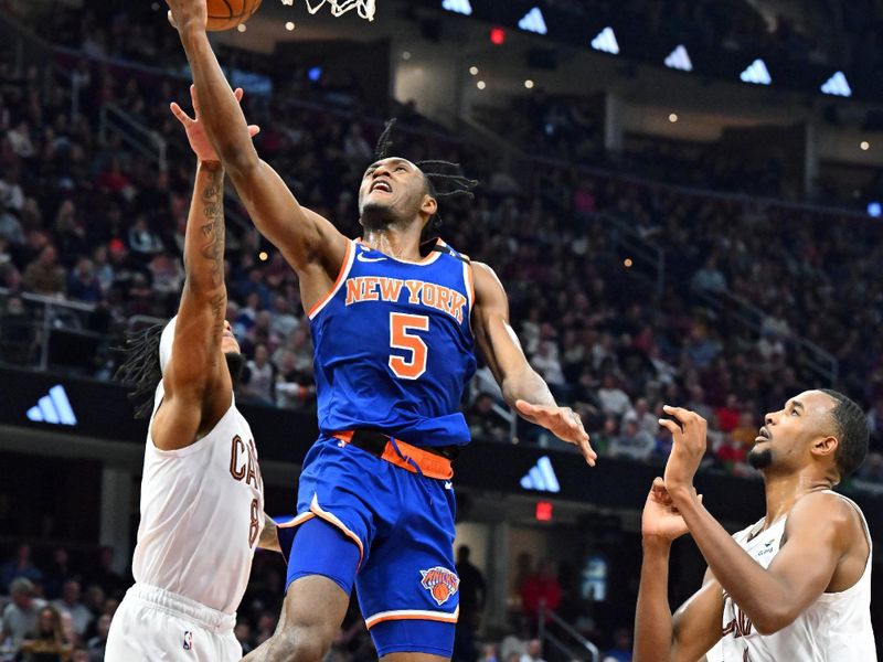 CLEVELAND, OHIO - MARCH 31: Quentin Grimes #6 of the New York Knicks shoots over Lamar Stevens #8 and Evan Mobley #4 of the Cleveland Cavaliers during the second quarter at Rocket Mortgage Fieldhouse on March 31, 2023 in Cleveland, Ohio. NOTE TO USER: User expressly acknowledges and agrees that, by downloading and or using this photograph, User is consenting to the terms and conditions of the Getty Images License Agreement. (Photo by Jason Miller/Getty Images)