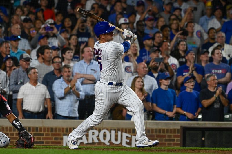 Jul 19, 2023; Chicago, Illinois, USA;  Chicago Cubs catcher Yan Gomes (15) hits a sacrifice fly RBI against the Washington Nationals during the eighth inning at Wrigley Field. Mandatory Credit: Matt Marton-USA TODAY Sports