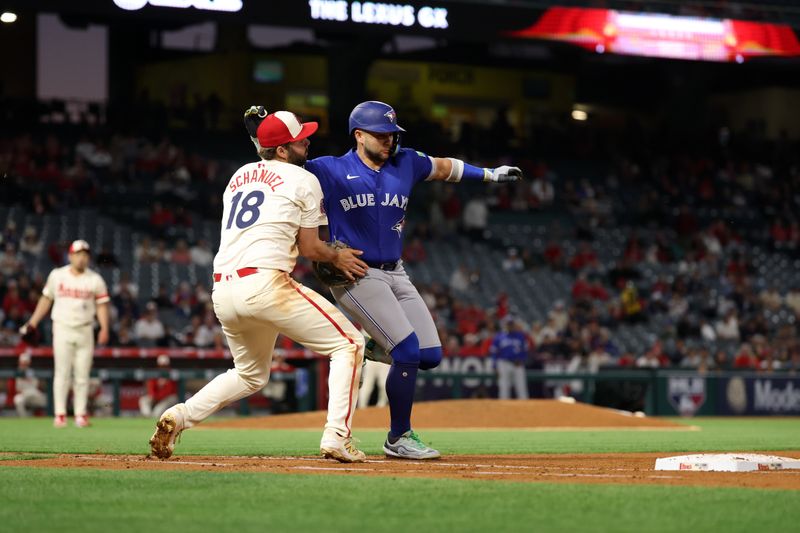 May 7, 2025; Anaheim, California, USA;  Toronto Blue Jays shortstop Bo Bichette (11) is tagged out by Los Angeles Angels first baseman Nolan Schanuel (18) during the sixth inning at Angel Stadium. Mandatory Credit: Kiyoshi Mio-Imagn Images