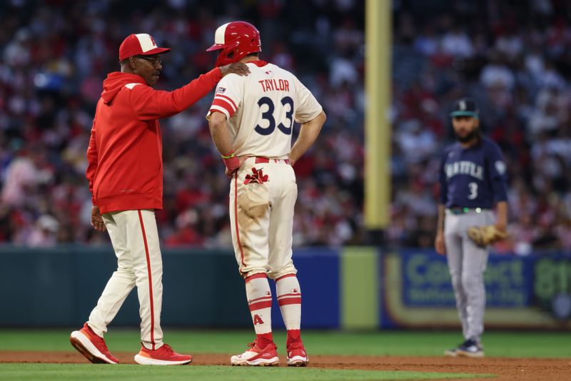 Jun 6, 2025; Anaheim, California, USA; Los Angeles Angels manager Ron Washington (37) talks to outfielder Chris Taylor (33) after he doubled during the fourth inning against the Seattle Mariners at Angel Stadium. Mandatory Credit: Jason Parkhurst-Imagn Images