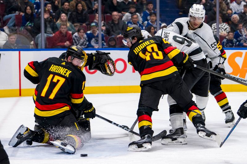 Mar 25, 2024; Vancouver, British Columbia, CAN; Vancouver Canucks defenseman Quinn Hughes (43) and defenseman Filip Hronek (17) battles with Los Angeles Kings forward Adrian Kempe (9) in the second period  at Rogers Arena. Mandatory Credit: Bob Frid-USA TODAY Sports