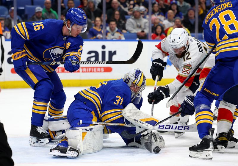 Feb 15, 2024; Buffalo, New York, USA;  Buffalo Sabres goaltender Eric Comrie (31) looks to cover up the puck as Florida Panthers left wing Jonah Gadjovich (12) tries to take a shot during the first period at KeyBank Center. Mandatory Credit: Timothy T. Ludwig-USA TODAY Sports