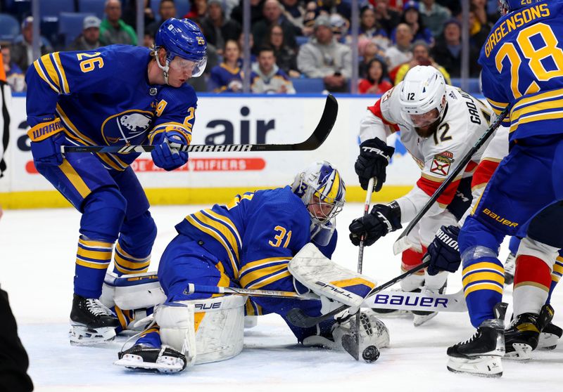 Feb 15, 2024; Buffalo, New York, USA;  Buffalo Sabres goaltender Eric Comrie (31) looks to cover up the puck as Florida Panthers left wing Jonah Gadjovich (12) tries to take a shot during the first period at KeyBank Center. Mandatory Credit: Timothy T. Ludwig-USA TODAY Sports