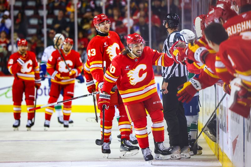 Sep 28, 2024; Calgary, Alberta, CAN; Calgary Flames left wing Ryan Lomberg (70) celebrates his goal with teammates against the Vancouver Canucks during the first period at Scotiabank Saddledome. Mandatory Credit: Sergei Belski-Imagn Images