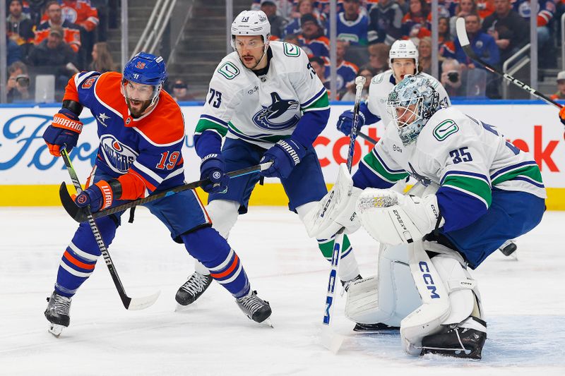 Jan 23, 2025; Edmonton, Alberta, CAN; Edmonton Oilers forward Adam Henrique (19) looks for a loose puck in front of Vancouver Canucks goaltender Thatcher Demko (35) during the first period at Rogers Place. Mandatory Credit: Perry Nelson-Imagn Images