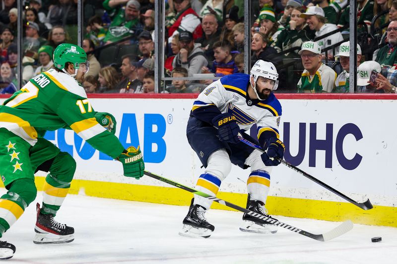 Mar 23, 2024; Saint Paul, Minnesota, USA; St. Louis Blues defenseman Nick Leddy (4) passes as Minnesota Wild left wing Marcus Foligno (17) defends during the third period at Xcel Energy Center. Mandatory Credit: Matt Krohn-USA TODAY Sports