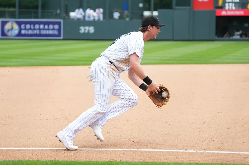 Jul 19, 2023; Denver, Colorado, USA; Colorado Rockies third baseman Ryan McMahon (24) fields the ball in the ninth inning against the Houston Astros at Coors Field. Mandatory Credit: Ron Chenoy-USA TODAY Sports