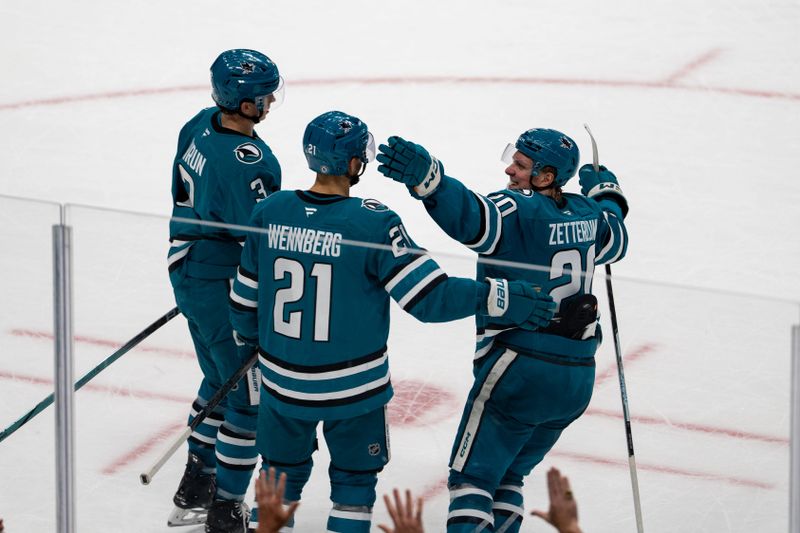 Nov 5, 2024; San Jose, California, USA;  San Jose Sharks center Alexander Wennberg (21) and San Jose Sharks defenseman Henry Thrun (3) and San Jose Sharks left wing Fabian Zetterlund (20) celebrate after the goal during overtime against the Columbus Blue Jackets at SAP Center at San Jose. Mandatory Credit: Neville E. Guard-Imagn Images