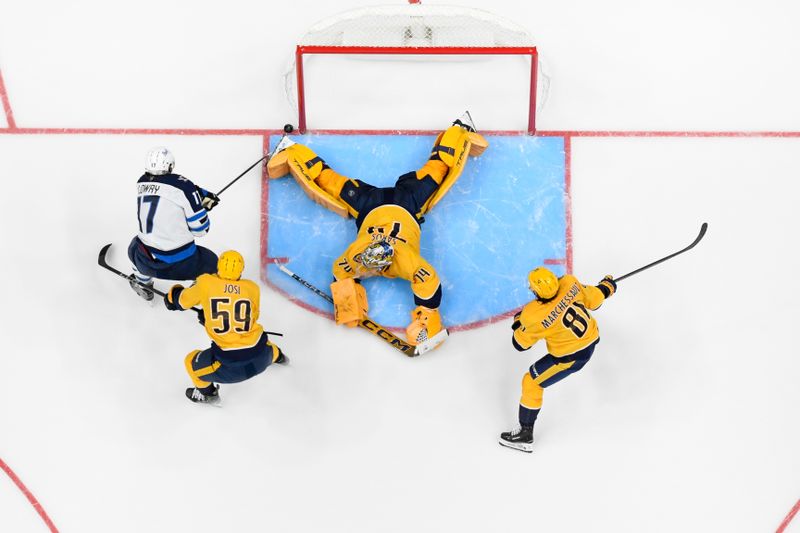 Nov 23, 2024; Nashville, Tennessee, USA;  Nashville Predators goaltender Juuse Saros (74) blocks the shot of Winnipeg Jets center Adam Lowry (17) during the third period at Bridgestone Arena. Mandatory Credit: Steve Roberts-Imagn Images