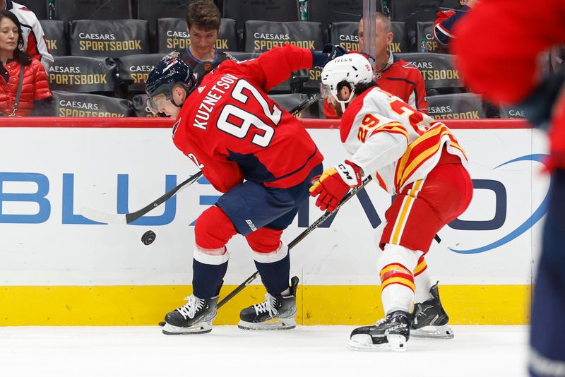 Oct 16, 2023; Washington, District of Columbia, USA; Washington Capitals center Evgeny Kuznetsov (92) attempts to control the puck as Calgary Flames center Dillon Dube (29) chases in the second period at Capital One Arena. Mandatory Credit: Geoff Burke-USA TODAY Sports