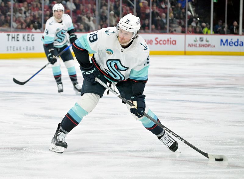 Dec 4, 2023; Montreal, Quebec, CAN; Seattle Kraken forward Jared McCann (19) takes a shot on net during the third period of the game against the Montreal Canadiens at the Bell Centre. Mandatory Credit: Eric Bolte-USA TODAY Sports