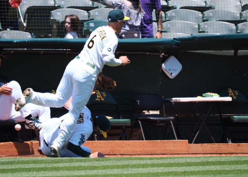 Jun 15, 2023; Oakland, California, USA; Oakland Athletics third baseman Jace Peterson (6) trips over shortstop Kevin Smith (4) after failing to catch a foul ball against the Tampa Bay Rays during the first inning at Oakland-Alameda County Coliseum. Mandatory Credit: Kelley L Cox-USA TODAY Sports