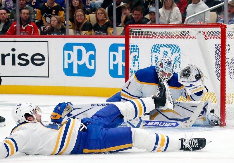 Oct 16, 2024; Pittsburgh, Pennsylvania, USA;  Buffalo Sabres goaltender Ukko-Pekka Luukkonen (1) makes a glove save against the Pittsburgh Penguins as defenseman Mattias Samuelsson (23) helps defend during the third period at PPG Paints Arena. Mandatory Credit: Charles LeClaire-Imagn Images