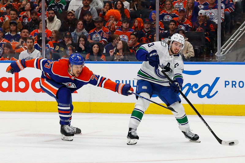 May 12, 2024; Edmonton, Alberta, CAN; Edmonton Oilers defensemen Vincent Desharnais (73) tries to prevent Vancouver Canucks defensemen Quinn Hughes (43) from taking a shot during the second period in game three of the second round of the 2024 Stanley Cup Playoffs at Rogers Place. Mandatory Credit: Perry Nelson-USA TODAY Sports