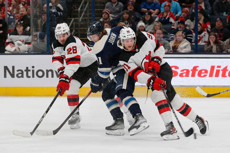 Jan 19, 2024; Columbus, Ohio, USA; New Jersey Devils center Dawson Mercer (91) takes the puck away from Columbus Blue Jackets left wing Kent Johnson (91) during the second period at Nationwide Arena. Mandatory Credit: Russell LaBounty-USA TODAY Sports