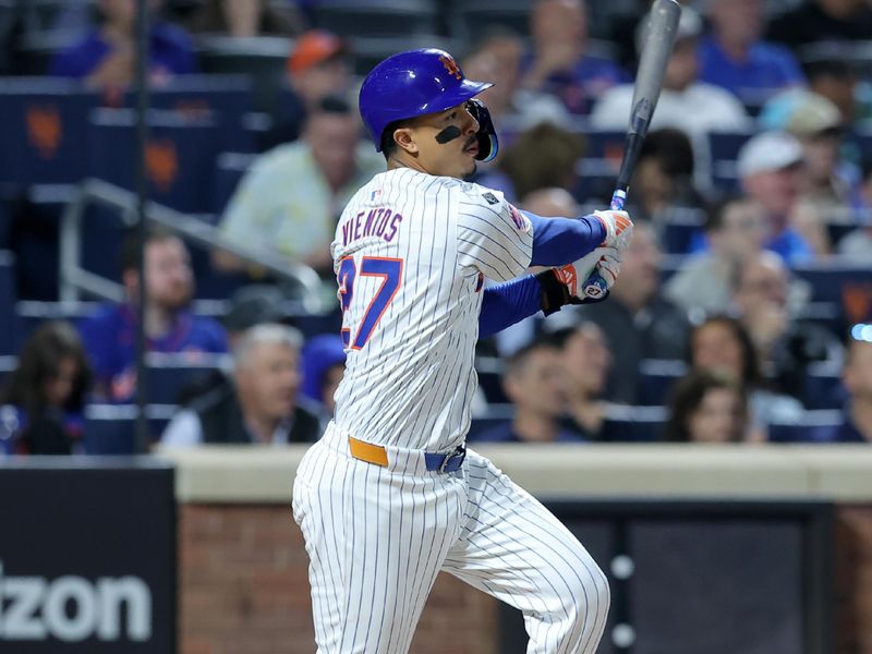 Sep 18, 2024; New York City, New York, USA; New York Mets third baseman Mark Vientos (27) follows through on a two run single against the Washington Nationals during the fourth inning at Citi Field. Mandatory Credit: Brad Penner-Imagn Images