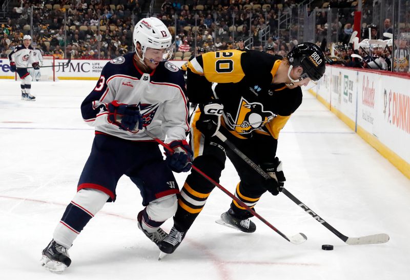 Mar 5, 2024; Pittsburgh, Pennsylvania, USA; Columbus Blue Jackets left wing Johnny Gaudreau (13) and Pittsburgh Penguins center Lars Eller (20) battle for the puck during the second period at PPG Paints Arena. The Penguins won 5-3. Mandatory Credit: Charles LeClaire-USA TODAY Sports