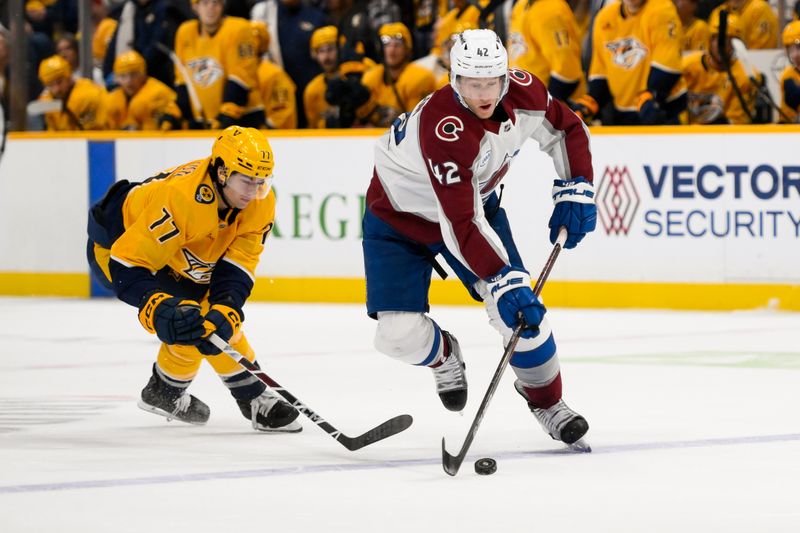 Nov 2, 2024; Nashville, Tennessee, USA;  Colorado Avalanche defenseman Josh Manson (42) skates with the puck as Nashville Predators right wing Luke Evangelista (77) chases during the second period at Bridgestone Arena. Mandatory Credit: Steve Roberts-Imagn Images