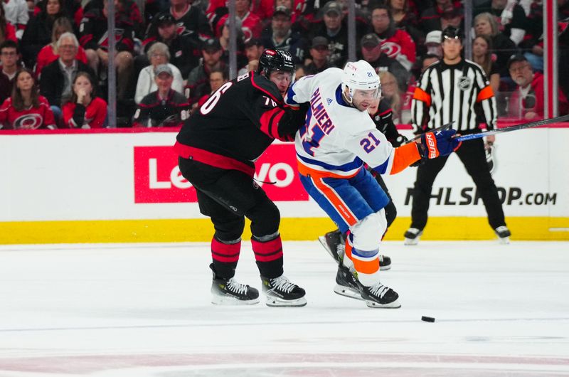 Apr 20, 2024; Raleigh, North Carolina, USA; New York Islanders center Kyle Palmieri (21) tries to control the puck against Carolina Hurricanes defenseman Brady Skjei (76) during the first period in game one of the first round of the 2024 Stanley Cup Playoffs at PNC Arena. Mandatory Credit: James Guillory-USA TODAY Sports